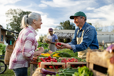 Farmer handing fresh produce to a customer