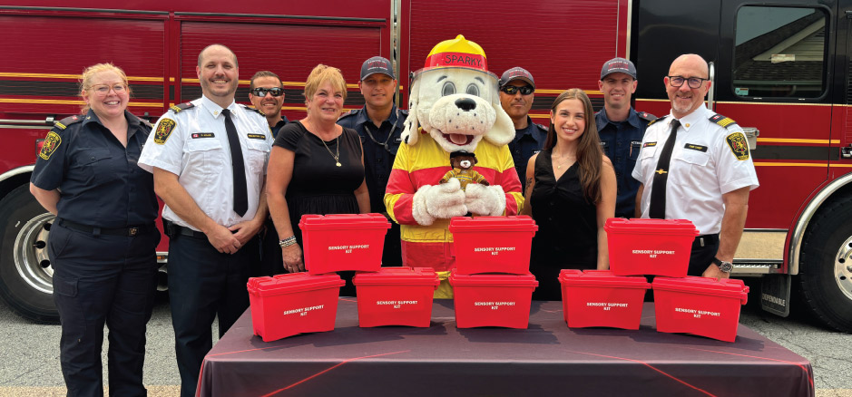 Image of people standing by fire truck with donated sensory kits